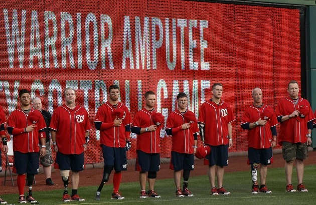 WASHINGTON, DC - APRIL 03: Members of the Washington Nationals Wounded Warrior softball team observe the national anthem before the start of the Wounded Warrior Amputee Celebrity Softball Classic at Nationals Park April 3, 2012 in Washington, DC. With a team comprised of veterans and active duty service members from across the United States who lost limbs while serving in Iraq or Afghanistan, members of the Washington Nationals Wounded Warrior softball team travel the country competing against able-bodied opponents. (Photo by Win McNamee/Getty Images) WASHINGTON, DC - APRIL 03: Members of the Washington Nationals Wounded Warrior softball team observe the national anthem before the start of the Wounded Warrior Amputee Celebrity Softball Classic at Nationals Park April 3, 2012 in Washington, DC. With a team comprised of veterans and active duty service members from across the United States who lost limbs while serving in Iraq or Afghanistan, members of the Washington Nationals Wounded Warrior softball team travel the country competing against able-bodied opponents. (Photo by Win McNamee/Getty Images)