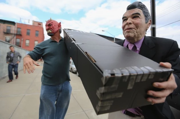NEW YORK, NY - APRIL 13: Satirist Randy Credico (R) is dressed as U.S. President Ronald Reagan while carrying a mock coffin for former British Prime Minister Margaret Thatcher with a man dressed as Satan at an 'Irish wake' for Thatcher at Rocky Sullivan's Irish bar on April 13, 2013 in the Brooklyn borough of New York City. The celebration of Thatcher's death was held by activists in response to her policies and governance of Northern Ireland in the 1980s. (Photo by Mario Tama/Getty Images) NEW YORK, NY - APRIL 13: Satirist Randy Credico (R) is dressed as U.S. President Ronald Reagan while carrying a mock coffin for former British Prime Minister Margaret Thatcher with a man dressed as Satan at an 'Irish wake' for Thatcher at Rocky Sullivan's Irish bar on April 13, 2013 in the Brooklyn borough of New York City. The celebration of Thatcher's death was held by activists in response to her policies and governance of Northern Ireland in the 1980s. (Photo by Mario Tama/Getty Images)